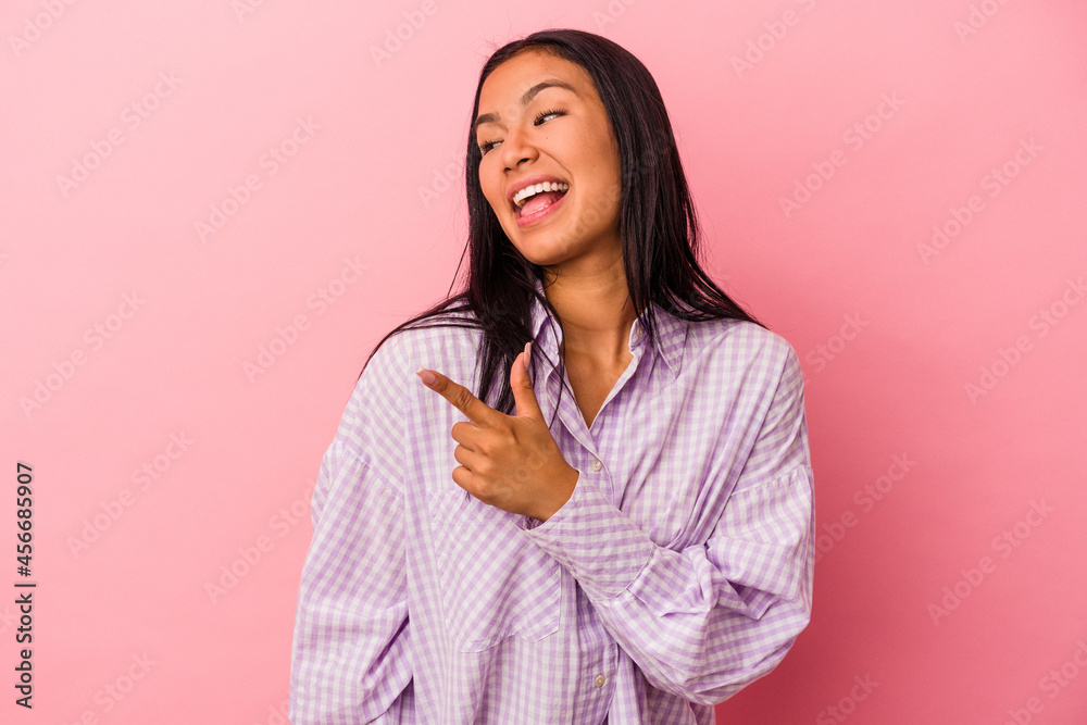 Young latin woman isolated on pink background looks aside smiling, cheerful and pleasant. Young latin woman isolated on pink background looks aside smiling, cheerful and pleasant.