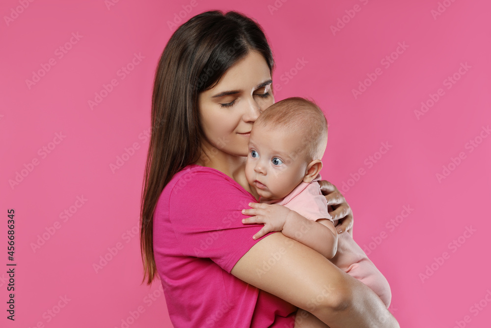 Beautiful mother with her cute baby on pink background Beautiful mother with her cute baby on pink background