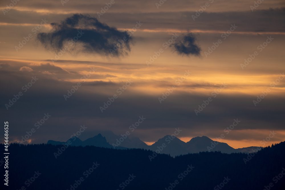 Golden sunrise on the mountains at a september morning with orange cloudy sky and view of the alps in austria
