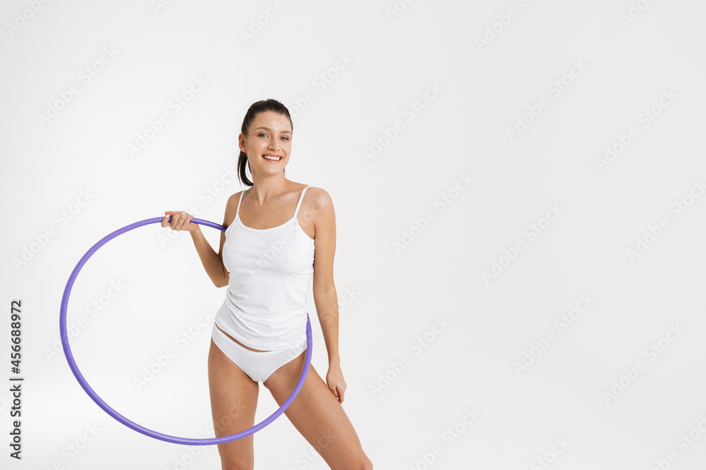 European woman wearing underwear smiling while posing with hula-hoop European woman wearing underwear smiling while posing with hula-hoop