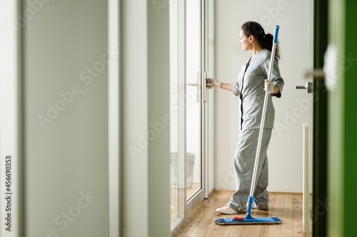 Middle eastern cleaning woman in uniform working with mop