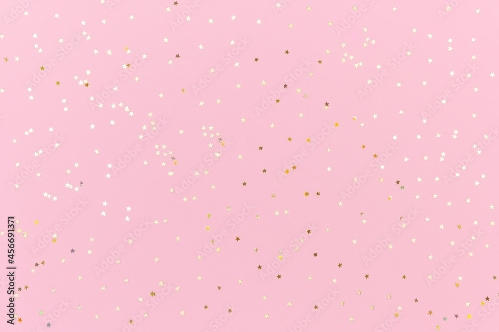 Pink background with gold sequins. Festive backdrop for your projects. Background for your product presentation. Top view, copy space.