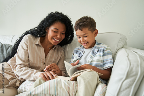 Little boy sitting at the sofa and holding his favorite book
