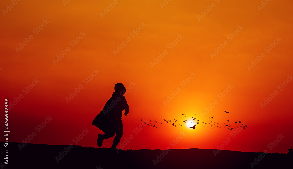 The silhouette of a superhero rushes forward with determination and determination. jogging with sun in the background, silhouette concept and evening running