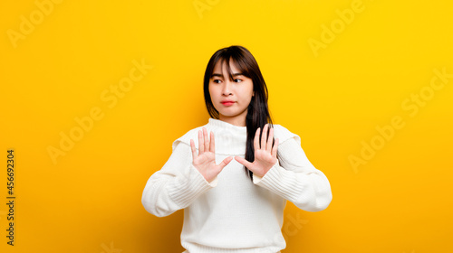 easily upset Portrait of an Asian girl Upset with arms to protect himself looking out lonely on a yellow background