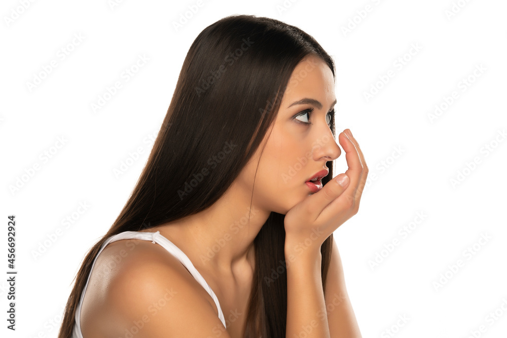 a young woman checks her breath with her palm a young woman checks her breath with her palm