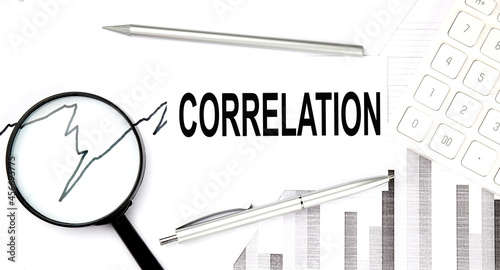 CORRELATION document with pen,graph and magnifier, calculator