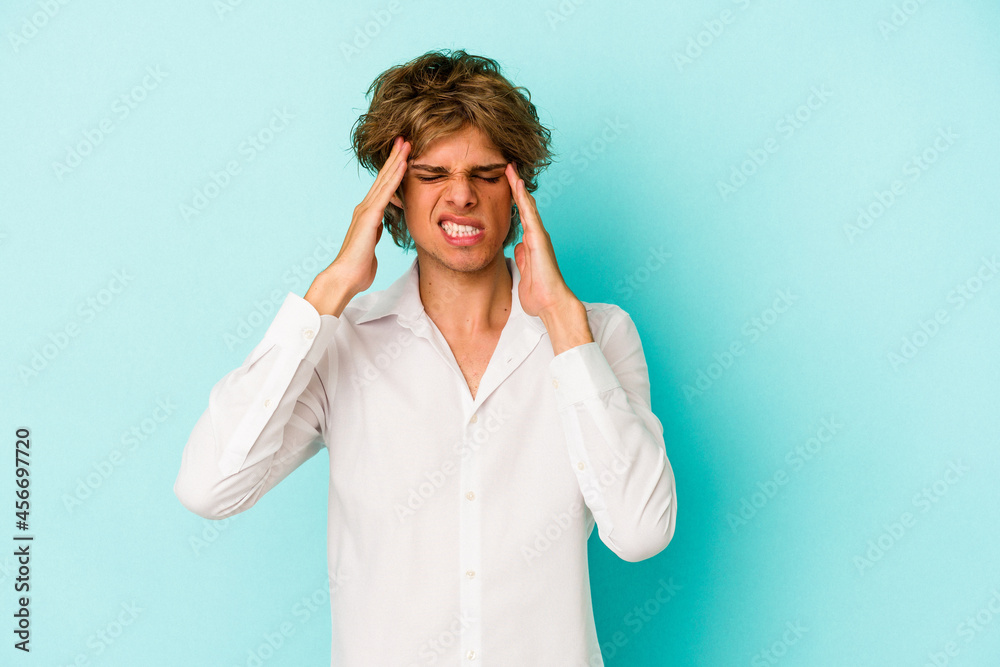 Young caucasian man with make up isolated on blue background touching temples and having headache. Young caucasian man with make up isolated on blue background touching temples and having headache.