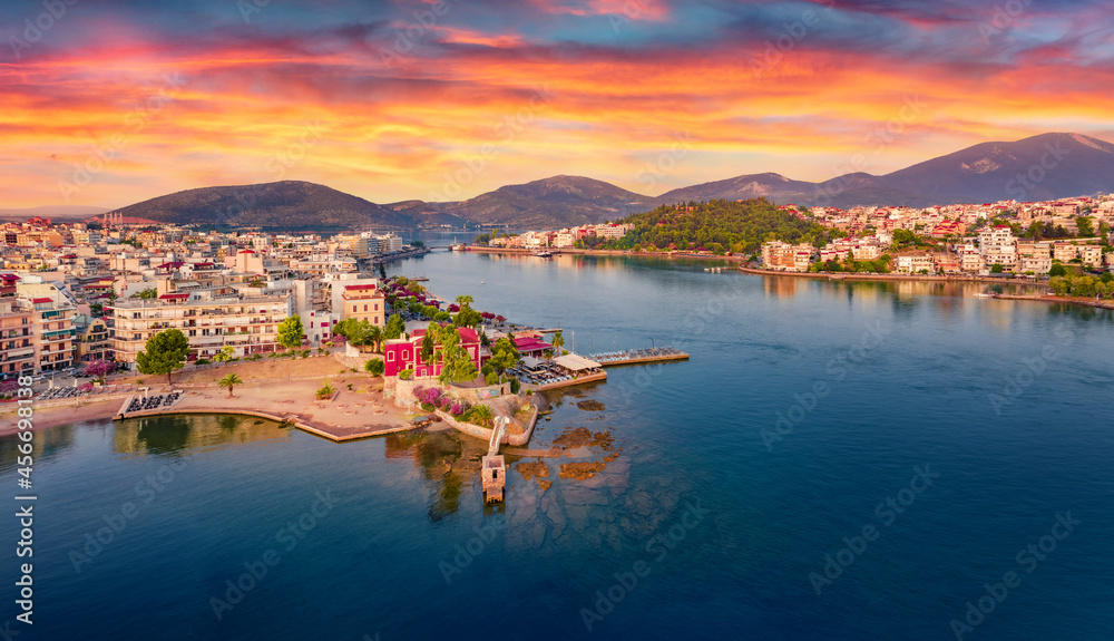 Colorful summer cityscape of Chalcis town. Dramatic sunrise on Aegean sea, North Euboean Gulf. Splendid morning scene of Euboea island, Greece, Europe. Traveling concept background.