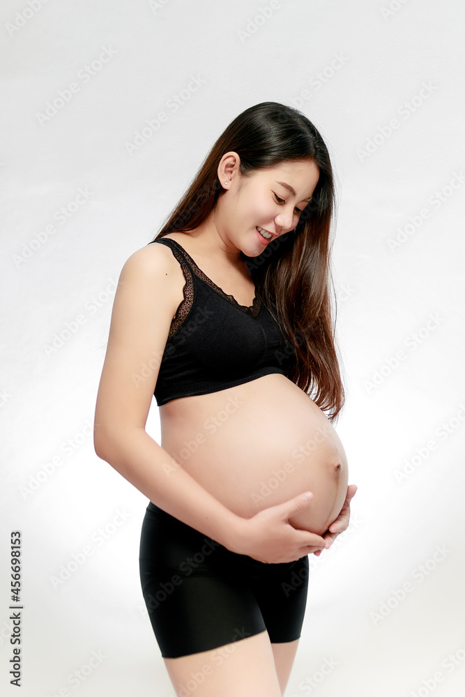 Pregnant asian woman hands holding on belly making a take care and love symbol on white background. Happy pregnant woman concept. Pregnant asian woman hands holding on belly making a take care and love symbol on white background. Happy pregnant woman concept.