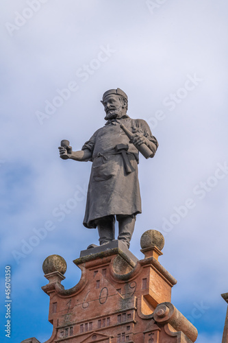 Colmar, France - 09 06 2021: The house of heads. Bronze statue of an Alsatian cooper by Bartholdi