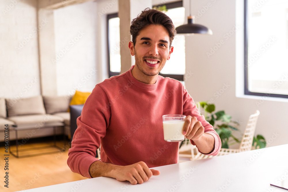 Young mixed race man drinking milk for breakfast Young mixed race man drinking milk for breakfast
