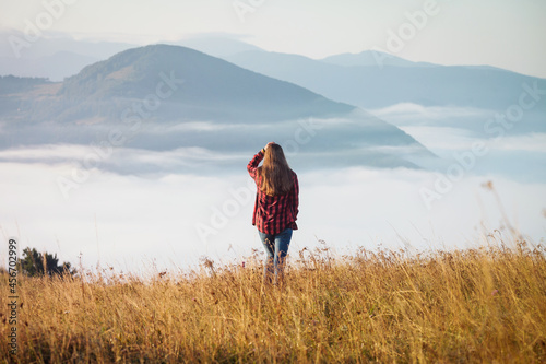 Young Girl in Foggy Autumn Landscape. Magical Morning Misty Carpathian Mountains 