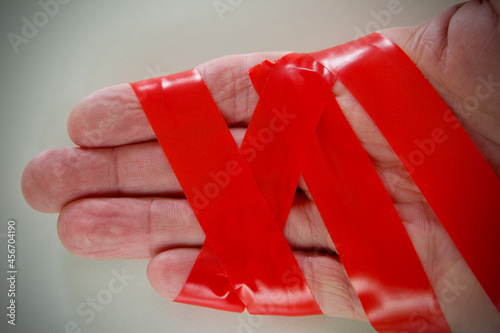 caucasian mans hand wrapped in red tape