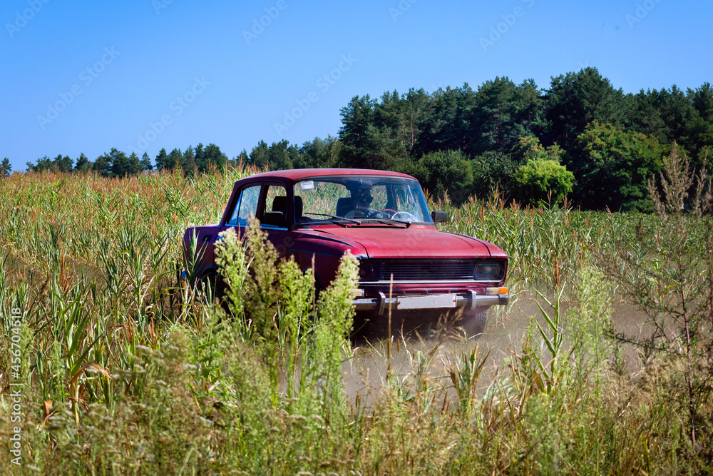 Old Soviet car drives off-road in a field Old Soviet car drives off-road in a field