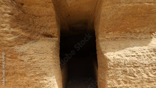 Walking through POV entering an Etruscan tomb. Etruscan Necropolis of the Caves - Populonia. Archaeological Park of Baratti and Populonia. Tuscany - Italy