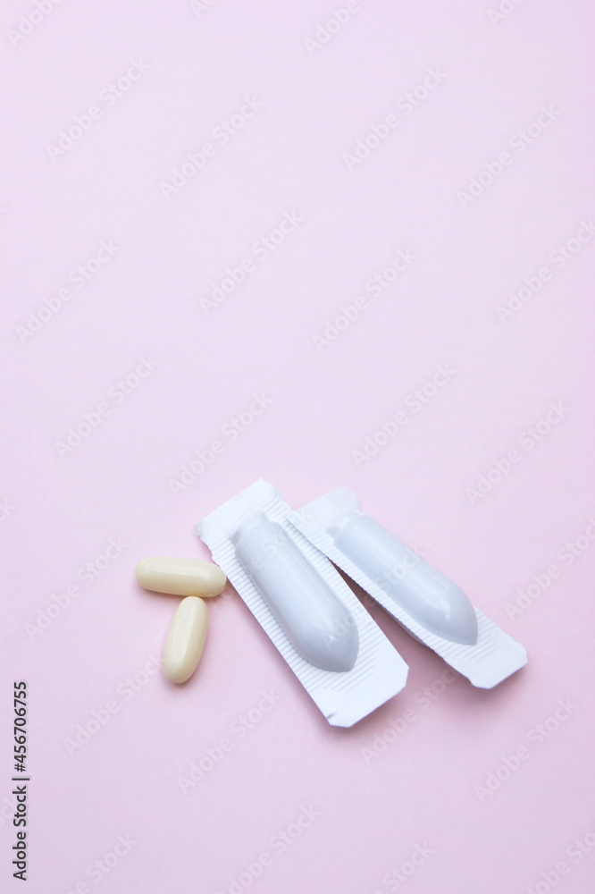 Gynecological medicines for women's health in form of suppository, capsules on pink background. Gynecological medicines for women's health in form of suppository, capsules on pink background.