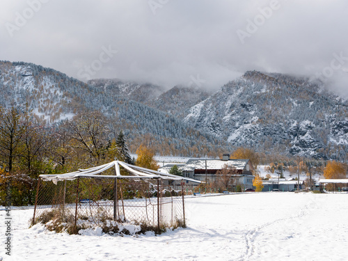 Russian village Chemal in the snow. View of the snow-capped Altai mountains and clouds. Chemal, Altai Republic, Russia