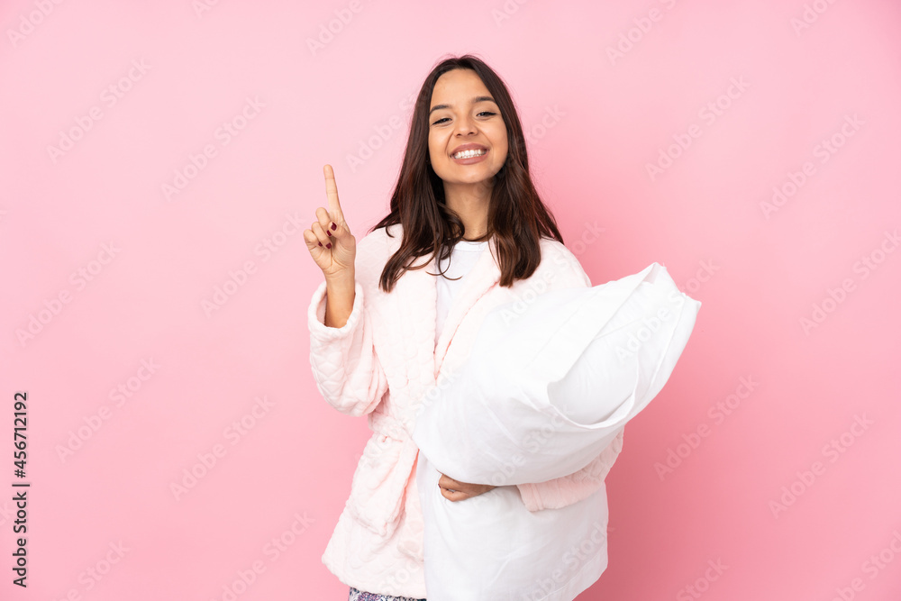 Young woman in pajamas isolated on pink background showing and lifting a finger in sign of the best Young woman in pajamas isolated on pink background showing and lifting a finger in sign of the best