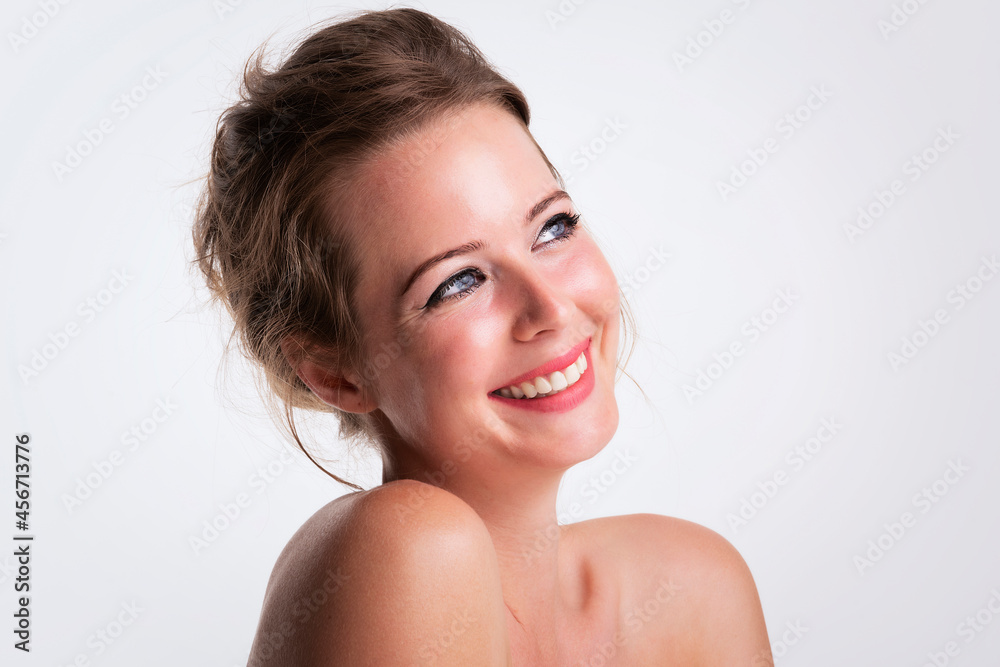 Beautiful young woman headshot with toothy smile at isolated white background with copy space Beautiful young woman headshot with toothy smile at isolated white background with copy space