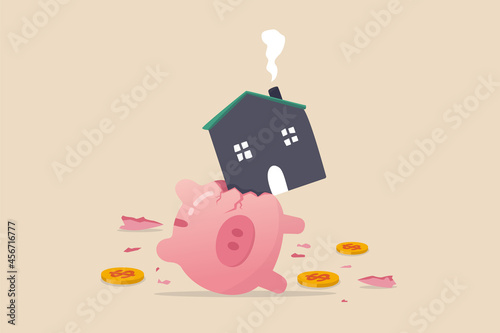 House expense and cost, too expensive payment or high interest rate mortgage concept, heavy house broke savings piggybank metaphor of too much payment and cost. photo