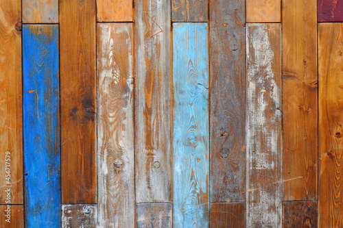 A natural, textured background of old vertical wooden boards with cracked paint of blue, white color.