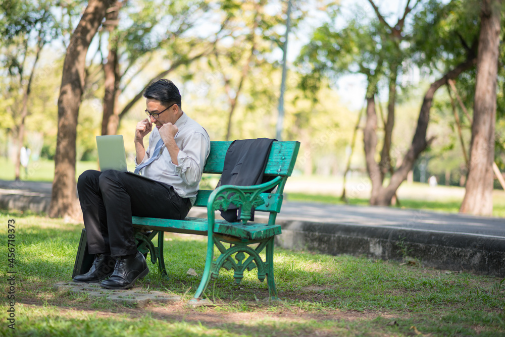 Young man using his laptop computer in the park Young man using his laptop computer in the park