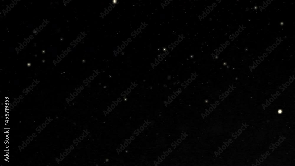 Lage and small Christmas snowflakes glitter and slowly whirl  against a black background