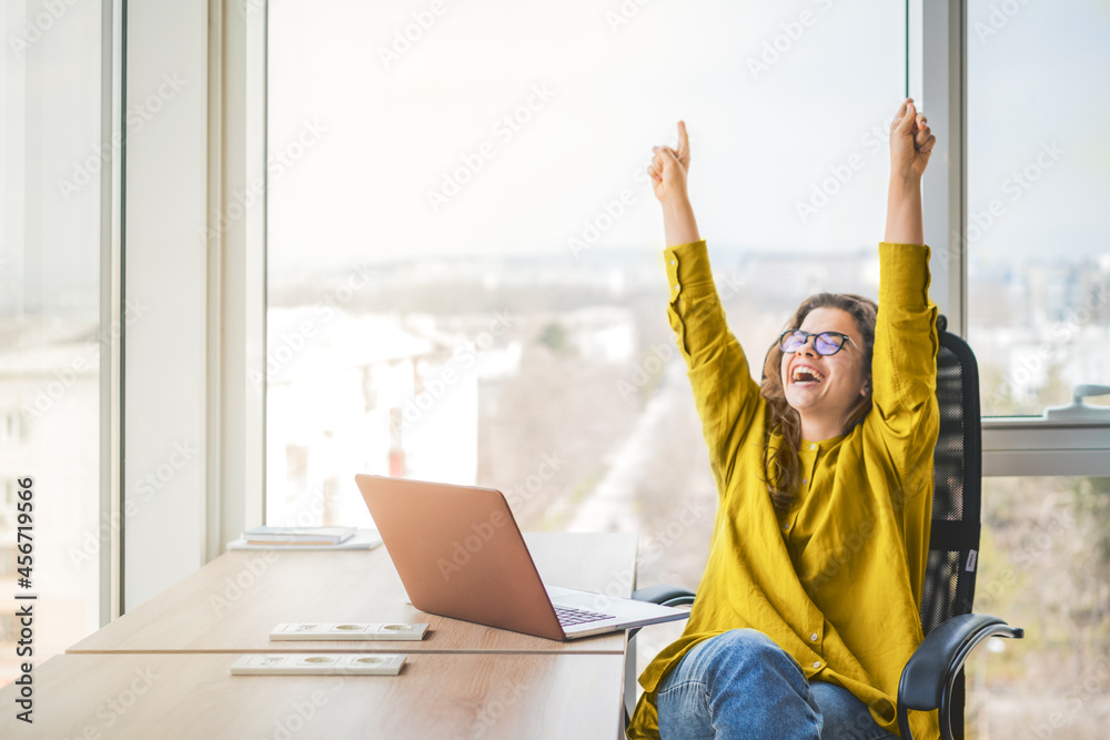 Happy successful businesswoman in yellow shirt raising fists with ambition. Women going up career ladder. Business achievement and promotion concept - obrazy, fototapety, plakaty 