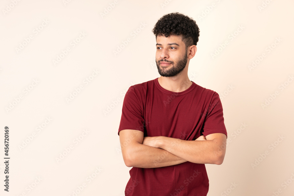 Young Moroccan man isolated on beige background looking to the side Young Moroccan man isolated on beige background looking to the side