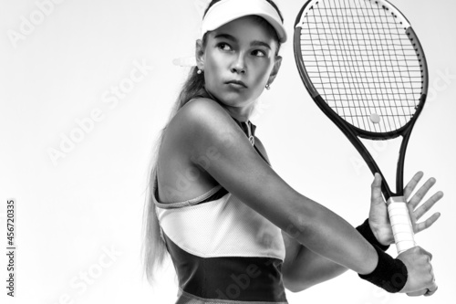 Tennis player. Beautiful girl teenager and athlete with racket in pink sporswear and hat on tennis court. Sport concept. © Mike Orlov
