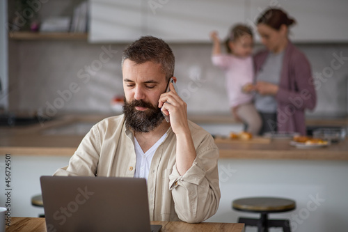 Businessman having video call indoors at home, everyday life and home office with child concept.