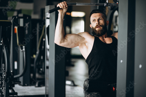 Handsome man bodybuilder doing workout at gym