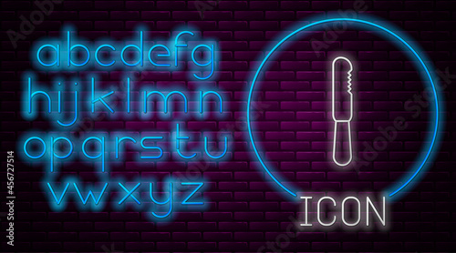 Glowing neon line Disposable plastic knife icon isolated on brick wall background. Neon light alphabet. Vector Illustration