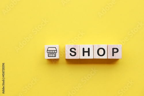 Wooden cube with the word SHOP which symbolizes trade, marketing concept.