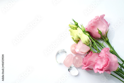 Beautiful pink eustoma  lisianthus  flowers in full bloom with rose quartz and rock crystal. Bouquet of flowers on a white background