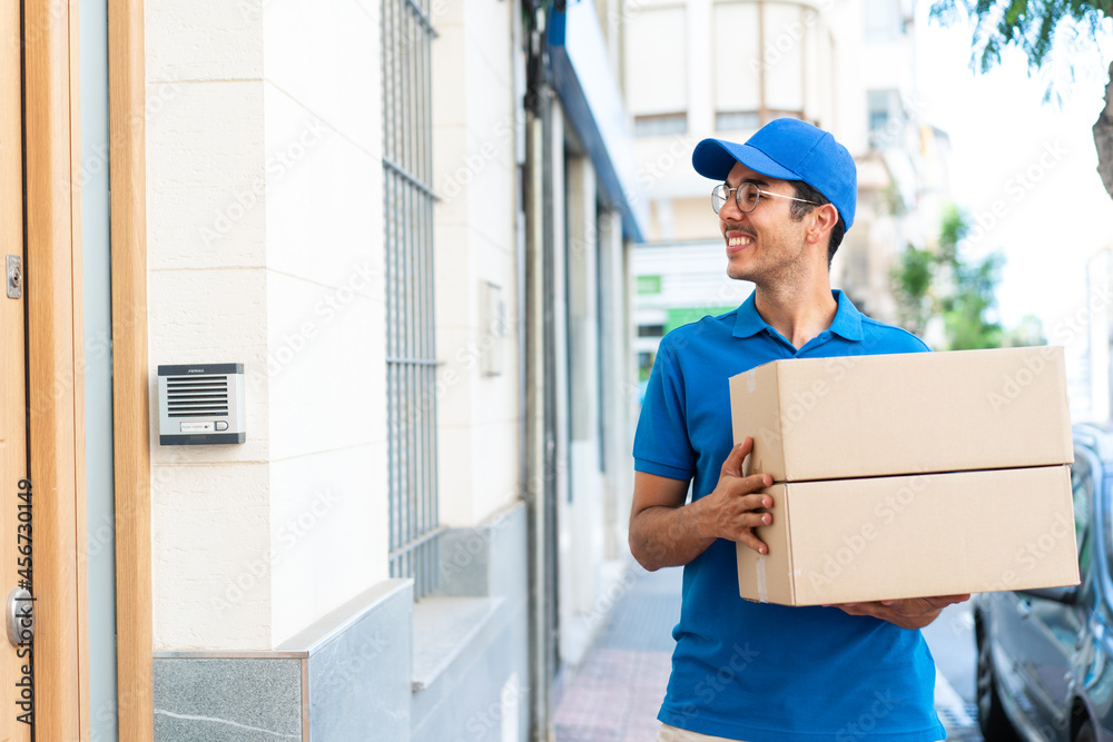 Young delivery man at outdoors holding boxes Young delivery man at outdoors holding boxes