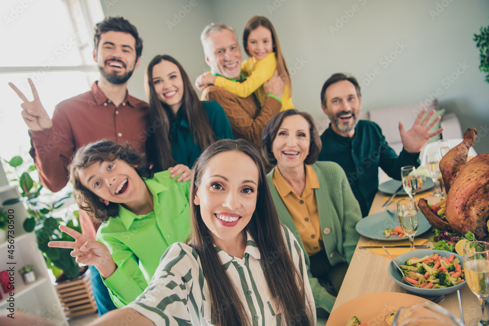 Self-portrait of attractive cheerful big full family meeting showing v-sign good mood having fun at home indoors