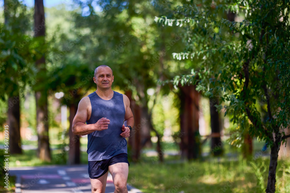 Man running in nature through the park, sports in the city. Man running in nature through the park, sports in the city.