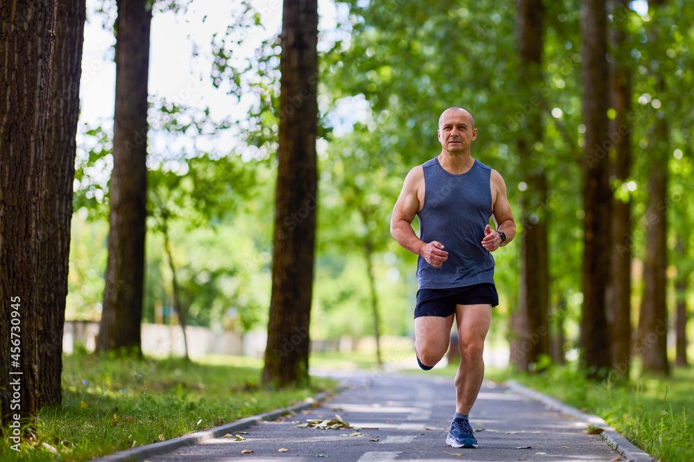 Man running in nature through the park, sports in the city. Man running in nature through the park, sports in the city.