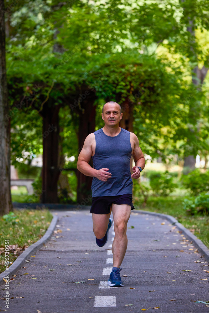 Man running in nature through the park, sports in the city. Man running in nature through the park, sports in the city.