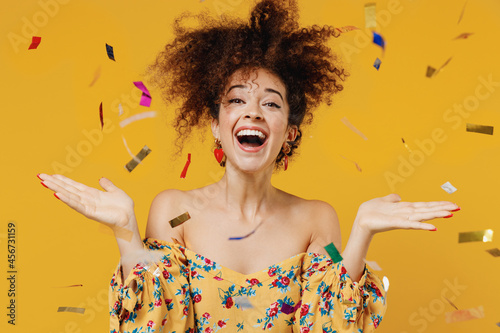 Canvastavla Young happy satisfied excited cheerful fun amazed woman 20s with culry hair in casual clothes tossing throwing confetti isolated on plain yellow background studio portrait