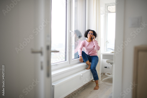 Portrait of happy mature woman making a phone call indoors.