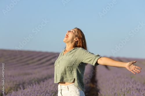Happy woman outstretching and screaming in a lavender field