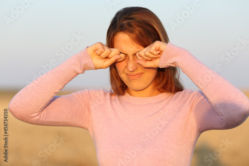 Woman scratching her ithy eyes due allergy photo