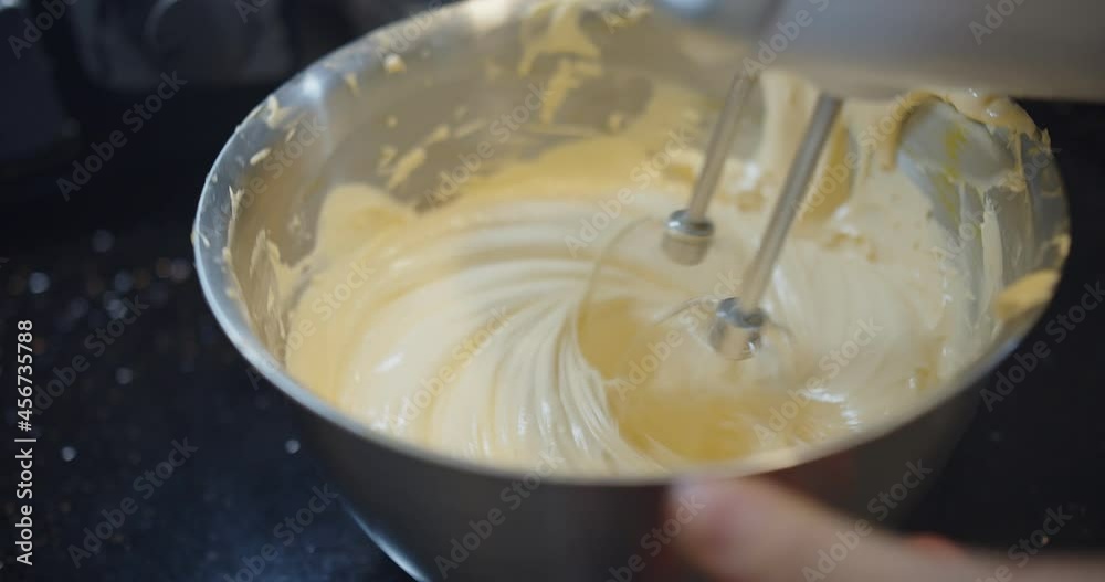 pastry chef preparing mixing Beating batter white egg yolks and sugar with hand mixer at the kitchen, Making homemade Sponge Cake pastry chef preparing mixing Beating batter white egg yolks and sugar with hand mixer at the kitchen, Making homemade Sponge Cake