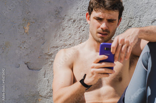 close-up of shirtless man using mobile