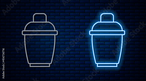 Glowing neon line Cocktail shaker icon isolated on brick wall background. Vector