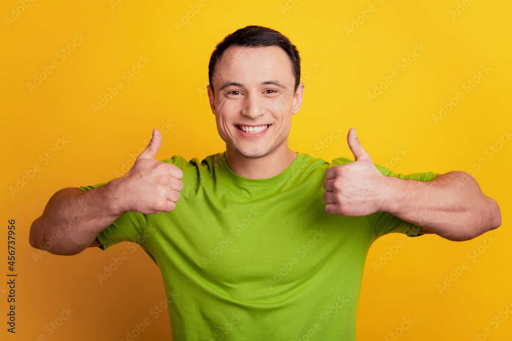 Portrait of cheeful handsome man raise thumb up symbol on yellow background Portrait of cheeful handsome man raise thumb up symbol on yellow background