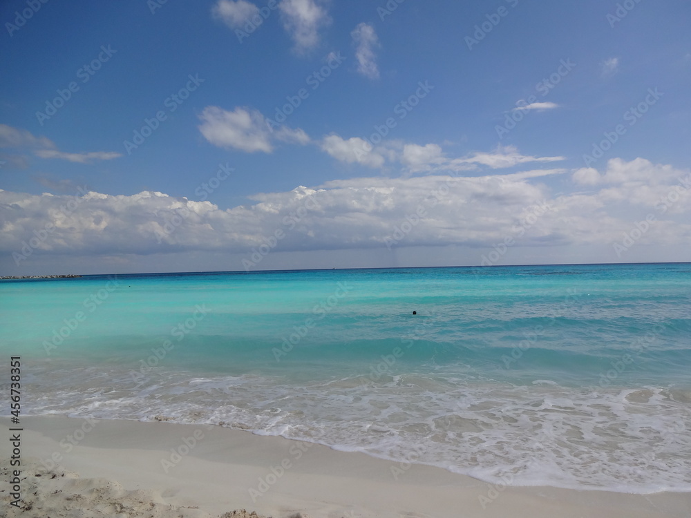 Blue sea and the sandy beach of Cancun in Mexico